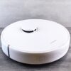 Een robotstofzuiger met dweilfunctie die een vloer reinigt in een modern huishouden.